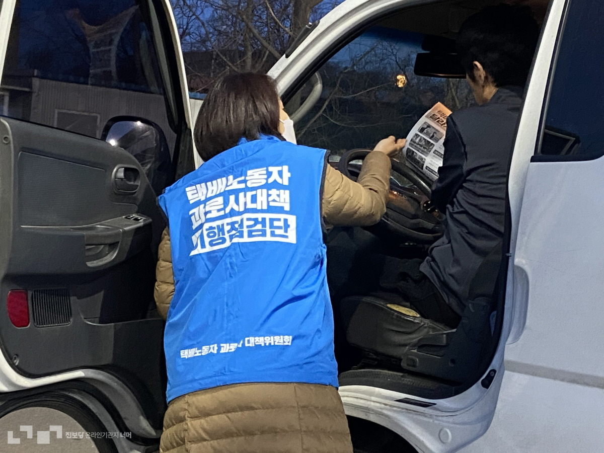 김재연 상임대표가 차 안에서 대기하던 택배노동자들을 찾아다니며 유인물을 나눠주고 있다. @너머